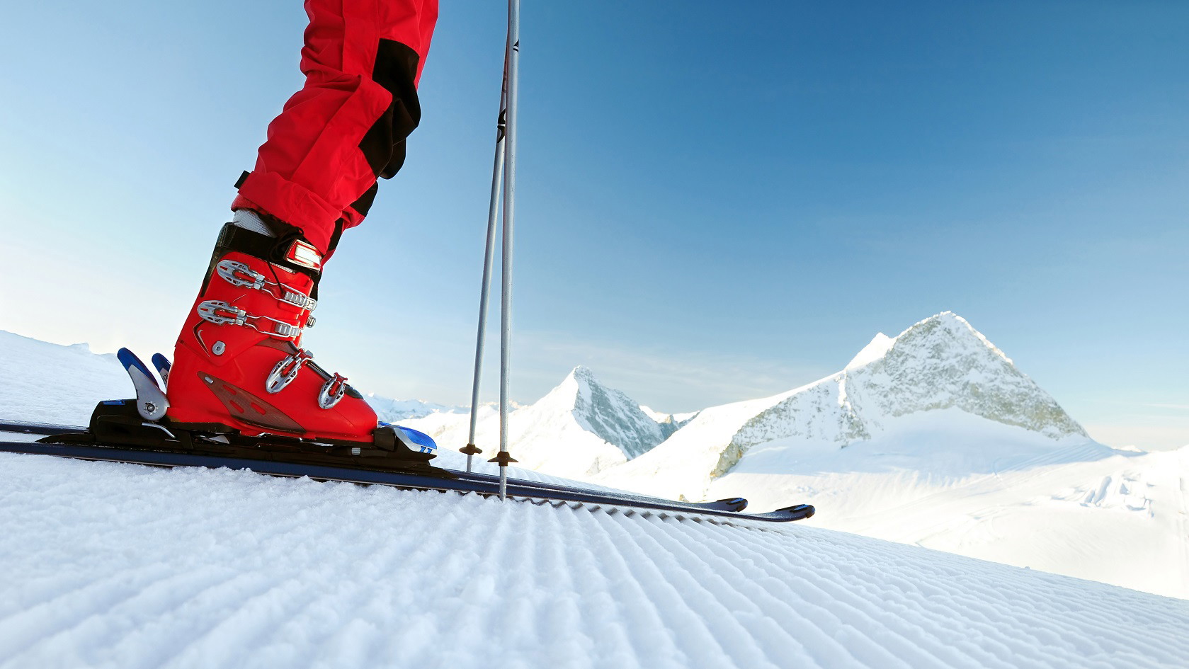 An image of a person wearing red ski boots on the mountain