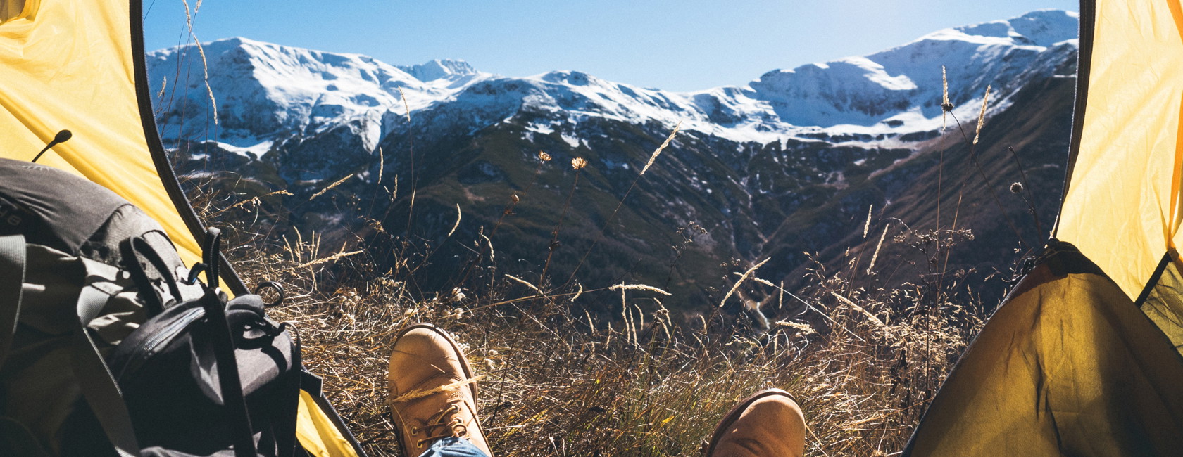 A person in a lightweight tent on a backpacking trip looking at the mountains 