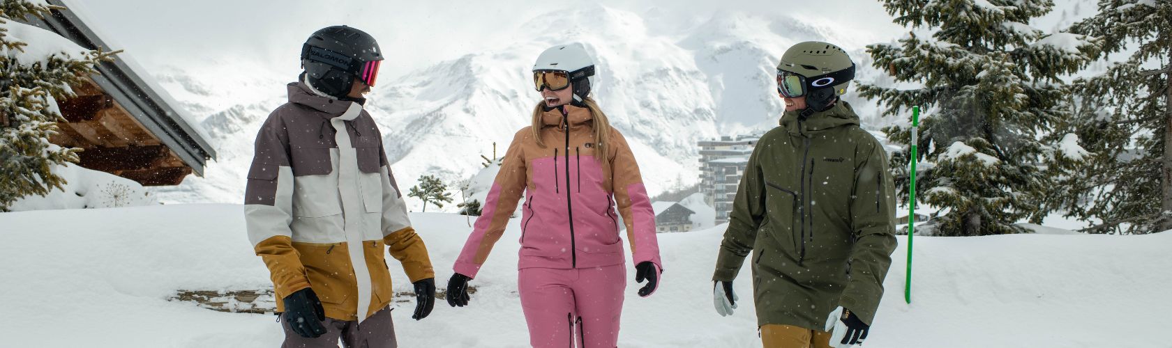 People dressed in snowsports gear and laughing in the snow