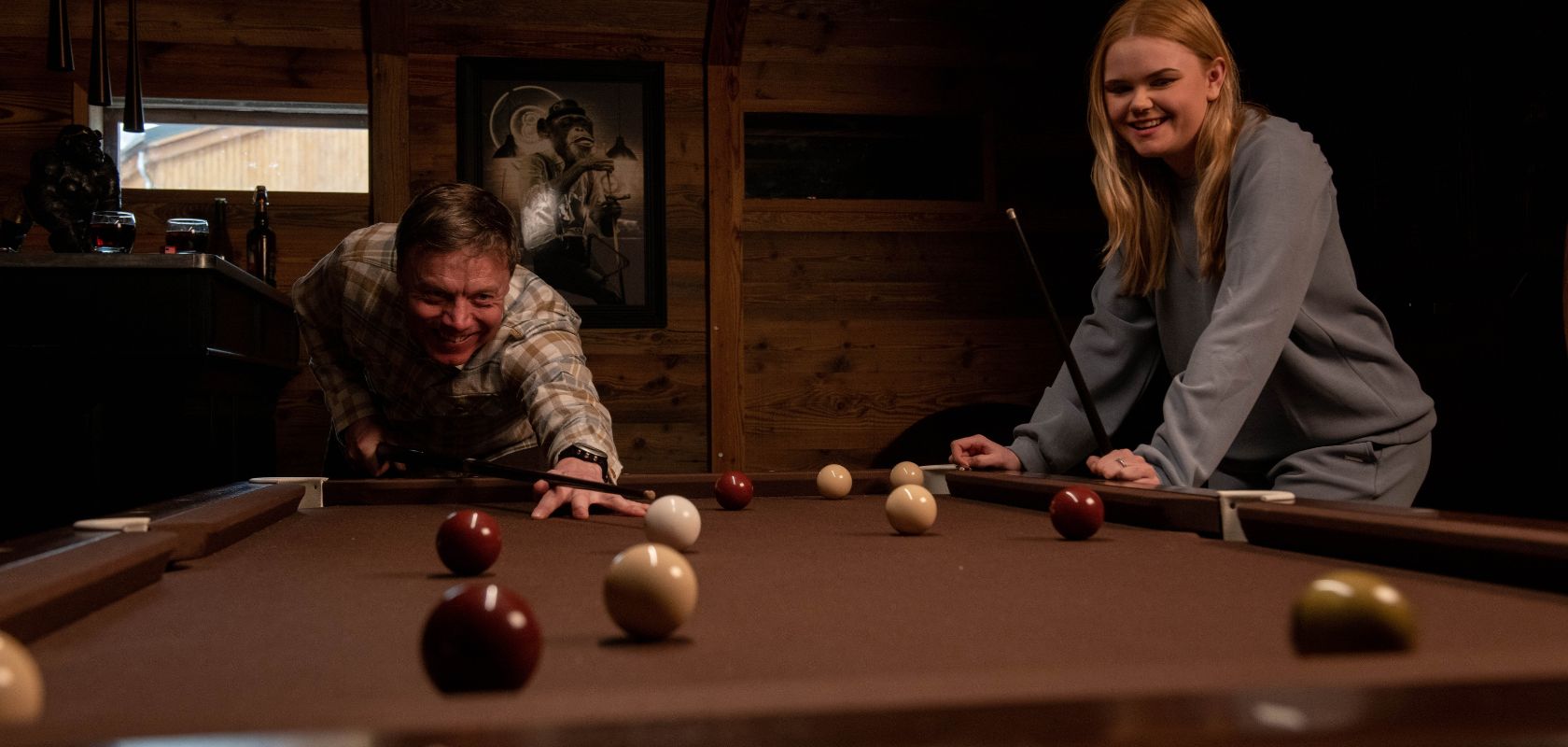 Two people playing pool in a ski resort bar during apres ski