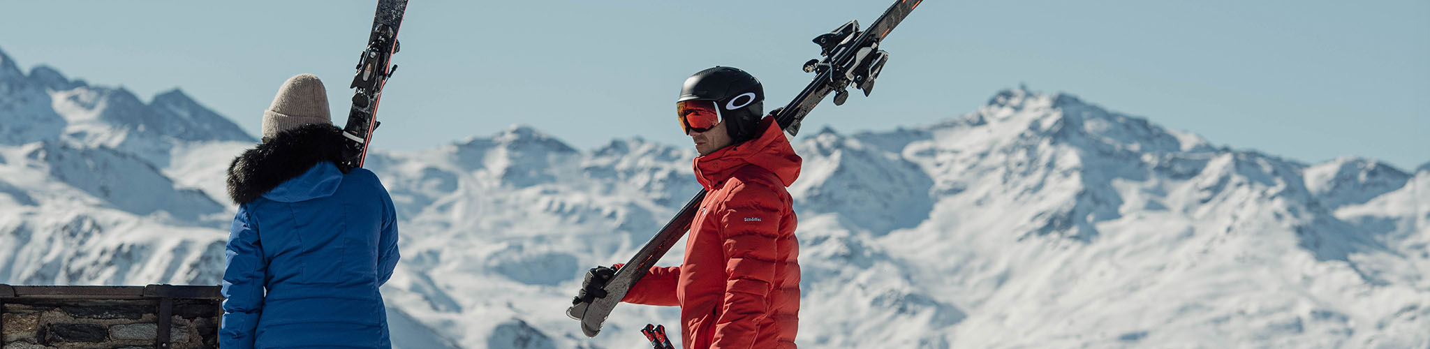 Shop skis. A man holding his skis on a snowy mountain